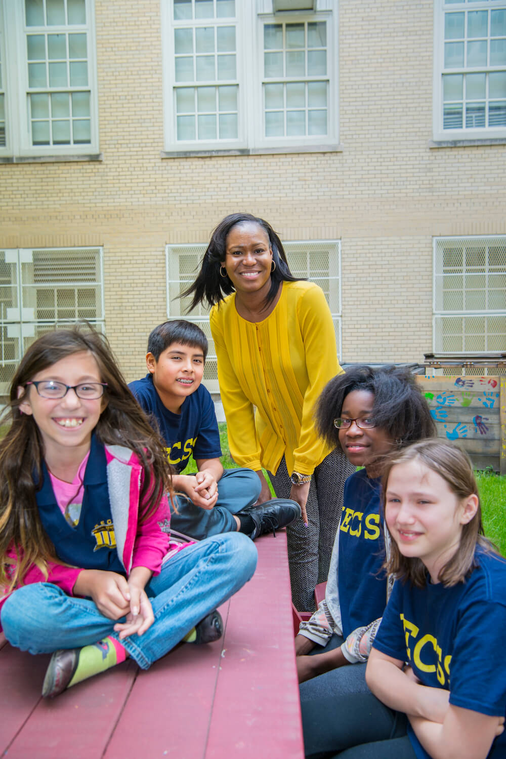 Tracee Murren, a 2010 alumna of Touro\'s Graduate School of Education, standing outside the school building with four of her students.